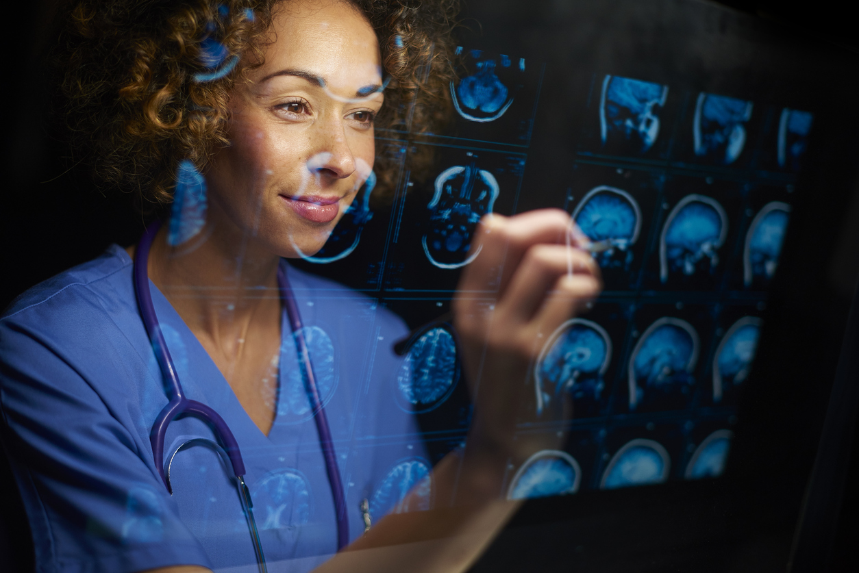 a female doctor or surgeon is analysing the digitally generated scans of a human brain