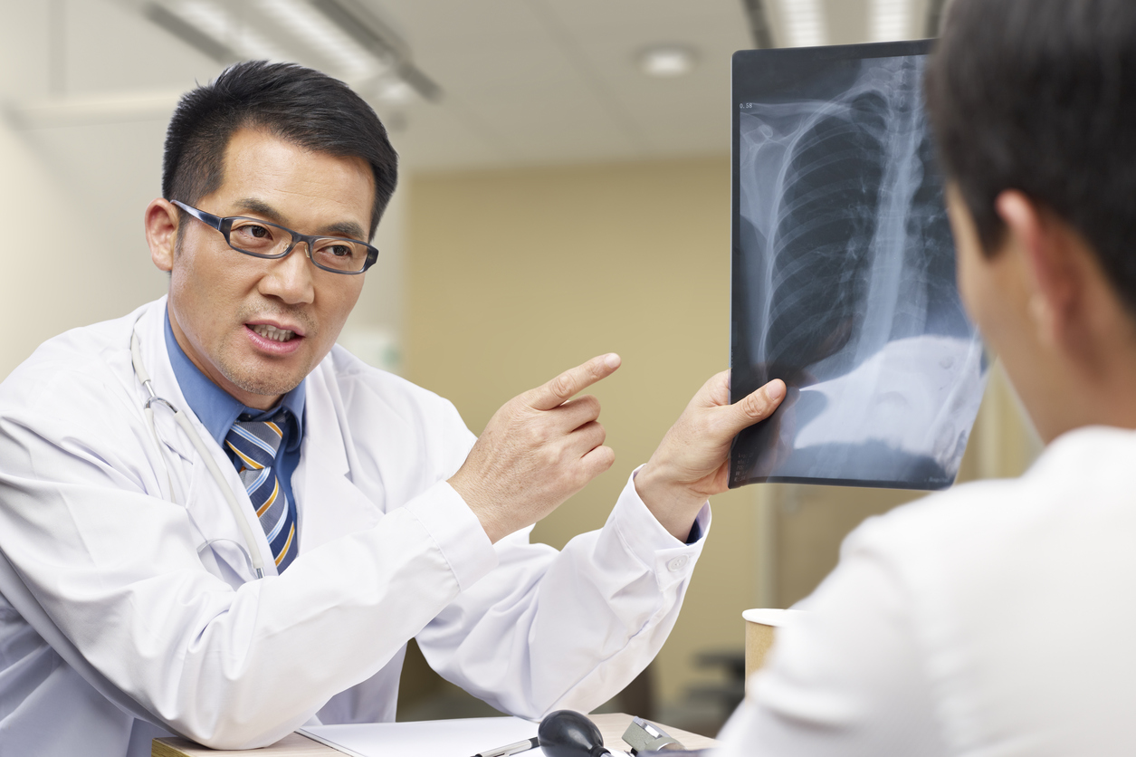 asian doctor talking to patient about x-ray result.